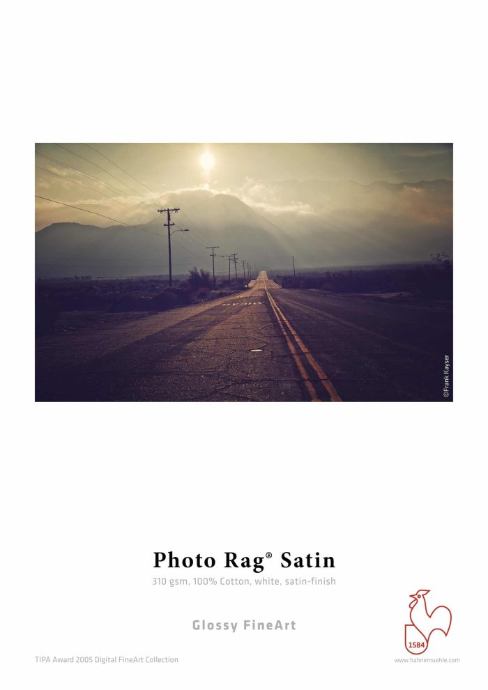 a road with power lines and mountains in the background